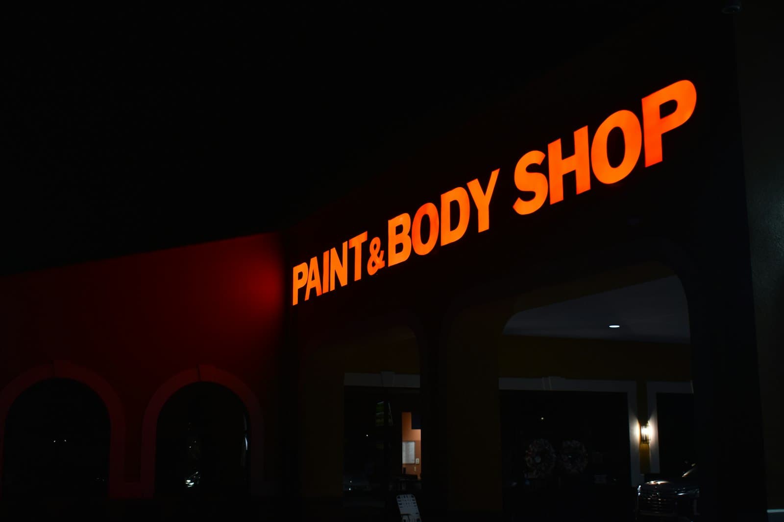 Upplyst skylt utanför en billackerings-verkstad